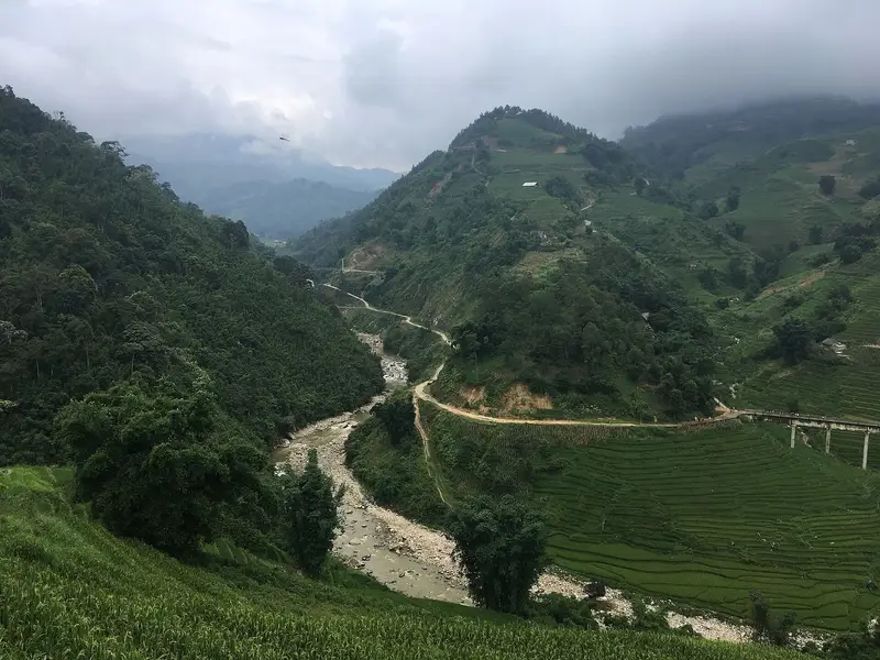 The Mường Hoa river winding through a green valley below Lao Chải